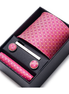 Pink patterned tie set with tie clip and cufflinks in a black box on a white background